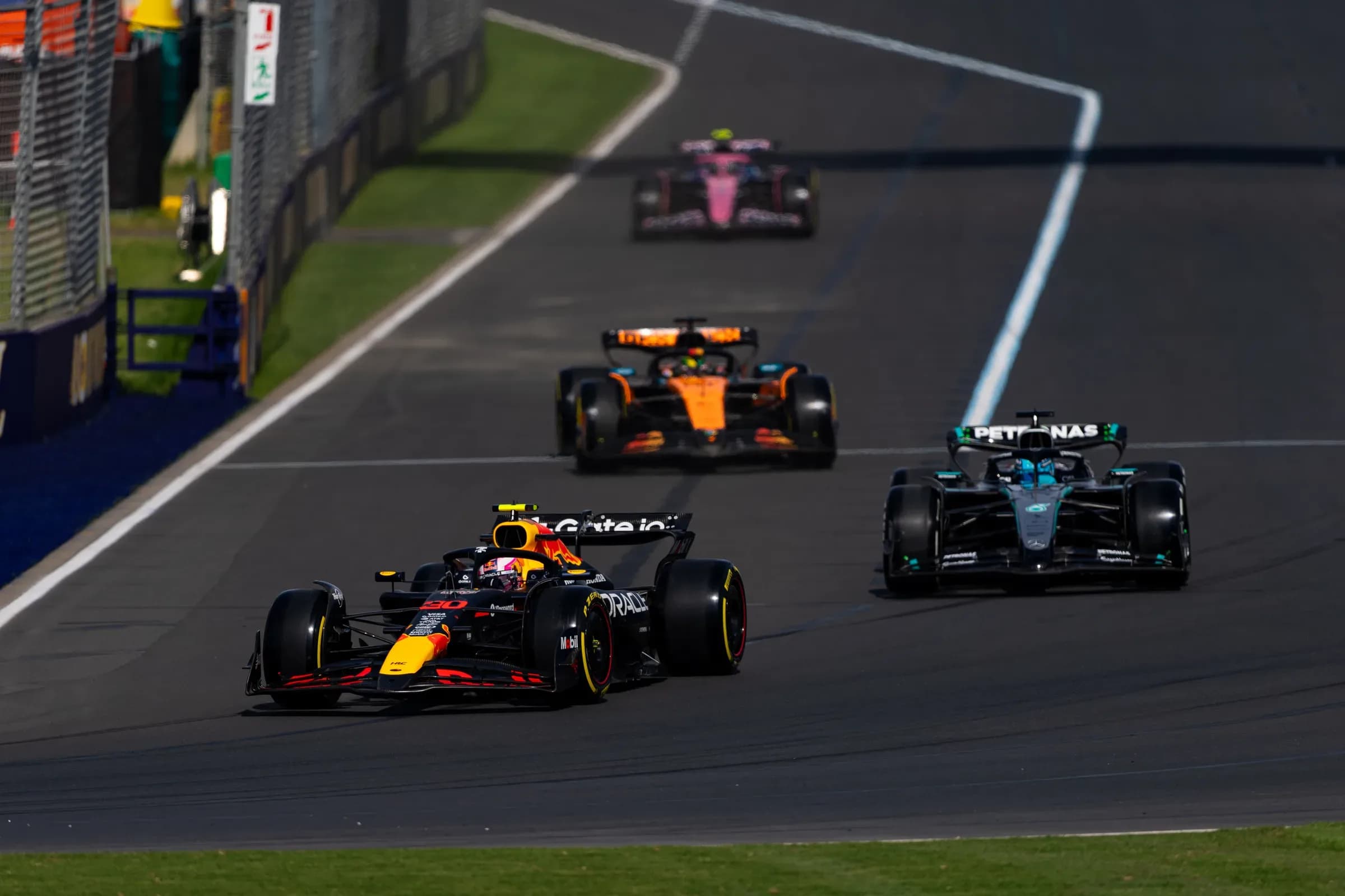 Formula 1 cars running nose to tail through a corner