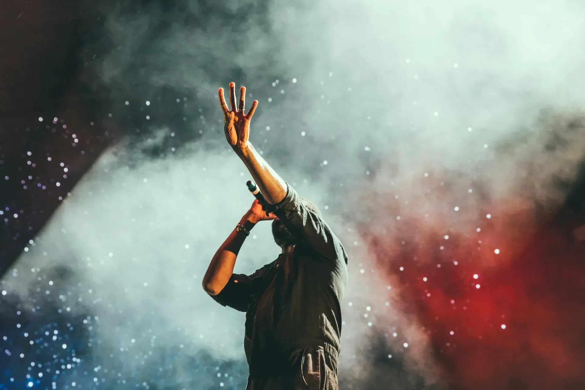 A singer on stage in haze and light